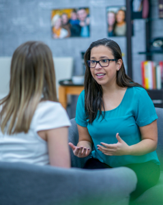 Community-Days header A woman in her early 30s explains something to a client who is sitting across from her. She looks passionate about what she is saying
